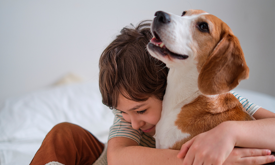 Imagem de criança abraçando cachorro