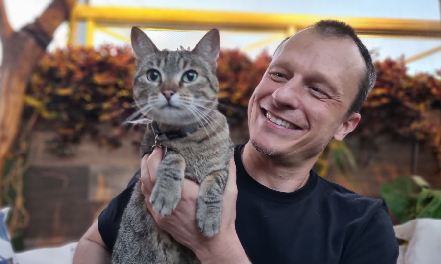 Dr. Pet sorrindo e segurando um gato nas mãos.